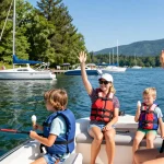 Boat motors for sale featured in a lively marina scene with families enjoying Kawagama Lake.